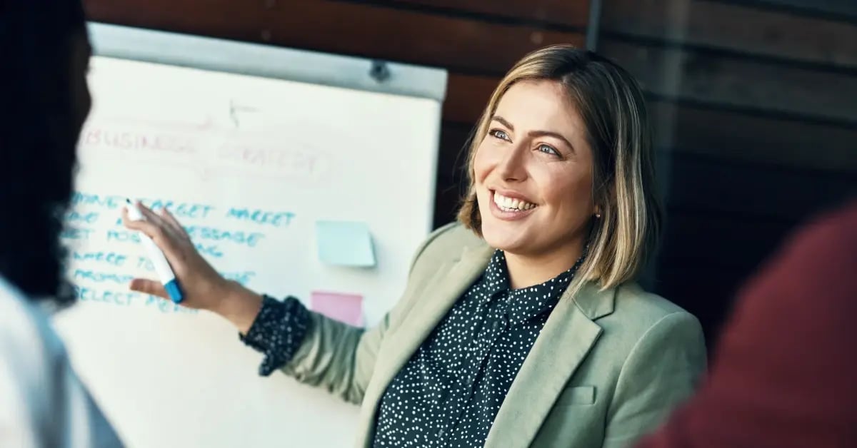 Executive Assistant sharing meeting destination options on a whiteboard to her exec