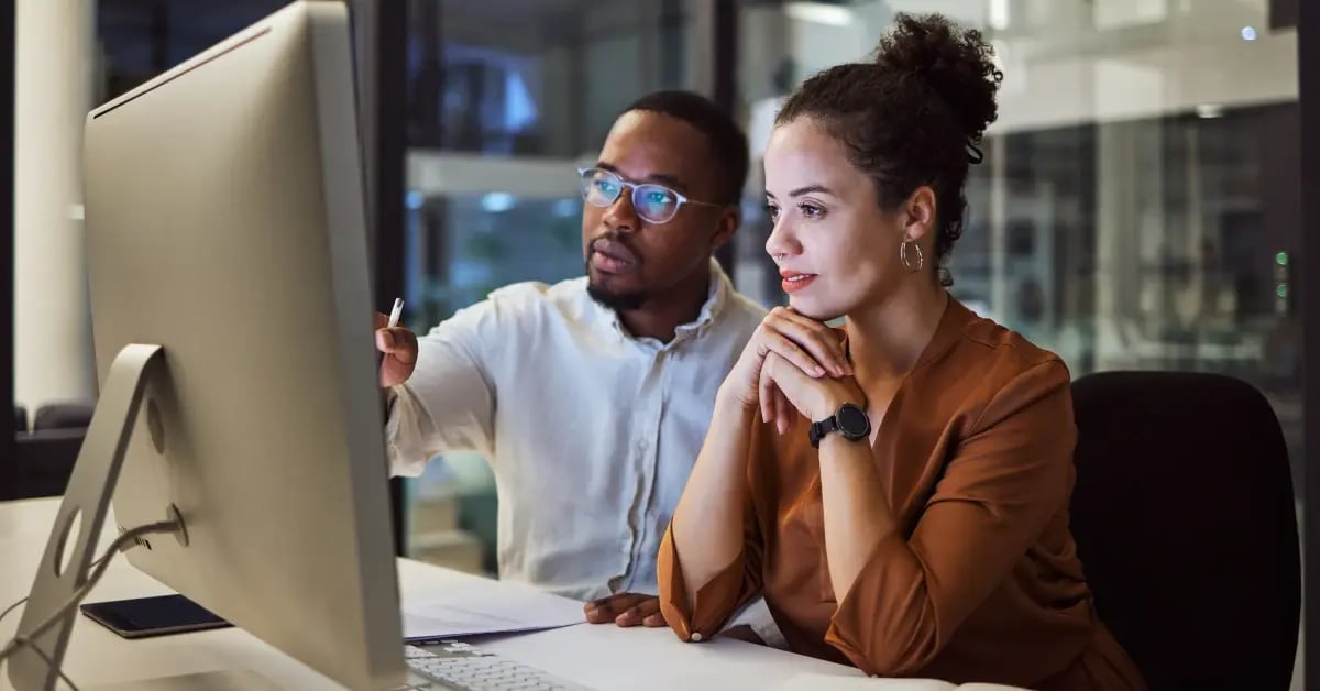 Male and female meeting planners in front of a computer in an office_